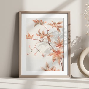 Op de afbeelding: Een ingelijste print van een botanische illustratie met een tak van delicate, oranje getinte bladeren op een witte achtergrond.