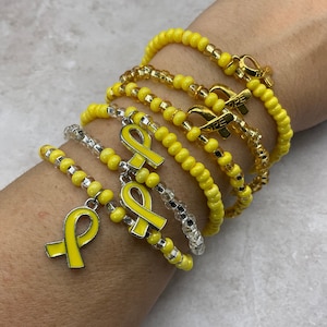 Sarcoma & bone cancer awareness glass seed bead stretch bracelet. Hope ribbon charm bracelet. Childhood cancer support. Yellow ribbon charm