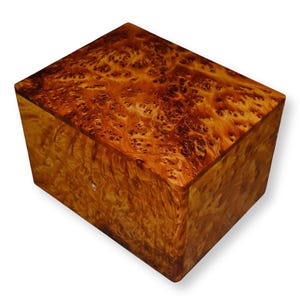 Op de afbeelding: Een rechthoekige houten doos met een opvallend wortelhoutnerfpatroon met wervelende gouden, amberkleurige en donkerbruine tinten. De doos heeft een gladde, gepolijste afwerking en een scharnierend deksel dat gelijk ligt met de zijkanten.