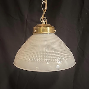 May include: A white frosted glass pendant light fixture with a brass chain and a brass ceiling mount. The glass shade has a textured, grid-like pattern.