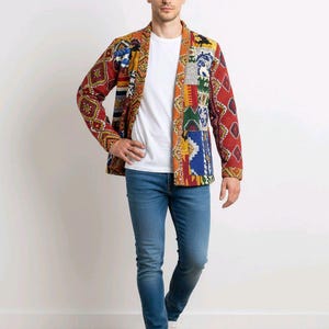 Peut inclure: Veste patchwork colorée avec divers motifs et couleurs, dont le rouge, le bleu, le jaune et le vert. Portée sur un t-shirt blanc, elle est associée à un jean bleu et des baskets blanches.