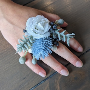 White rose, blue thistle, sage green; ring corsage;artificial