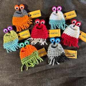 Yip Yips. Mini crochet yip yip with pocket hug tag. Multi color yip yips with tag. One mini yip yip with a hug tag.