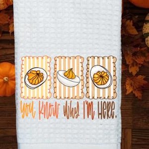 May include: White waffle-weave kitchen towel with a decorative border featuring three images of deviled eggs. The text "You Know What I'm Here" is printed in orange and yellow. Pumpkins and fall leaves surround the towel.