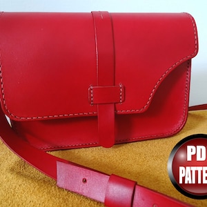 Puede incluir: Un bolso de hombro de cuero rojo con cierre de solapa y una correa. El bolso tiene un diseño sencillo y está hecho de cuero de alta calidad. PATRÓN PDF.