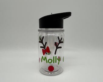 May include: A clear plastic water bottle with a black lid and a red and green reindeer design. The bottle has the name "Molly" written on it.