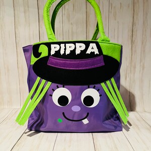May include: Purple Halloween trick-or-treat bag with a witch face, green hair, and a black hat. The bag has the name "PIPPA" written on it.