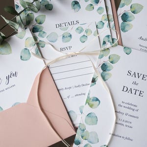 Op de afbeelding: Een set huwelijksstationery met een aquarel eucalyptusontwerp. De kaarten omvatten een save the date, RSVP, details en een bedankkaart. De tekst op de save the date-kaart luidt "Save the Date to celebrate the wedding of Audrey & Emmett 11.3.2018 Austin, Texas Invitation to follow".