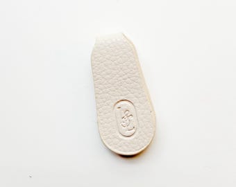 Può includere: Una tazza di ceramica bianca con manico nero e la scritta "But First, Coffee" in nero, in grassetto. La tazza è appoggiata su una superficie di legno. La tazza è alta circa 10 cm.