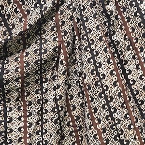 Könnte beinhalten: Brauner und weißer Stoff mit einem sich wiederholenden Muster aus wellenförmigen Linien und Wirbeln.