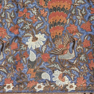 May include: A blue and white fabric with a traditional Indonesian batik pattern. The pattern features peacocks, flowers, and leaves. The fabric is woven with a fine detail and intricate design.