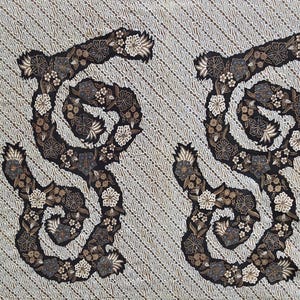 May include: A white fabric with a repeating pattern of black floral designs. The design features a series of swirls and loops, creating a flowing and intricate pattern.