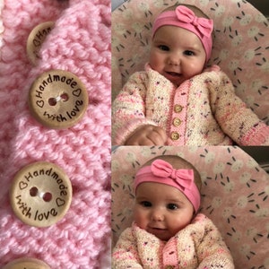 May include: A pink knitted cardigan with wooden buttons that say "Handmade with love". The cardigan is worn by a baby girl wearing a pink headband with a bow.