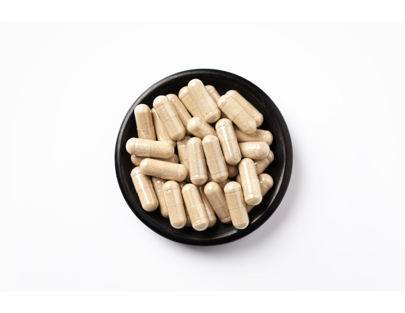 Peut inclure: Un bol noir rempli de capsules brun clair. Les capsules sont dispos&eacute;es en tas, certaines d&eacute;bordant du bol.