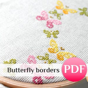 May include: A close-up of a cross-stitch design with butterfly borders in pink, yellow, and green on white fabric. The image includes the text "Butterfly borders" and a pink "PDF" icon.