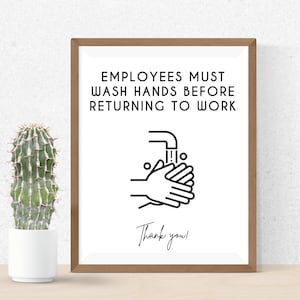 May include: A framed sign with the text "EMPLOYEES MUST WASH HANDS BEFORE RETURNING TO WORK" and an illustration of hands being washed under a faucet. Below the illustration is the text "Thank you!" A cactus in a white pot is to the left.