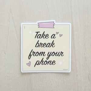 May include: A yellow sticker with a pink tape design and the text "Take a break from your phone" with hearts and stars.