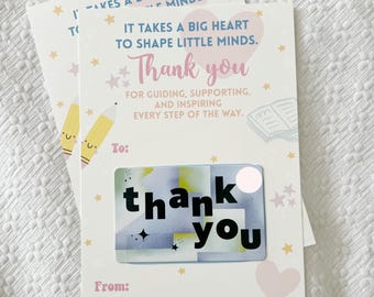 May include: A white card with pink and blue accents. It says "It takes a big heart to shape little minds. Thank you for guiding, supporting, and inspiring every step of the way."  There is a gift card that says "thank you" on it.