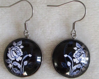white rose earrings on black background