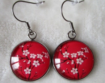 round cherry blossom earrings on a pink/red background