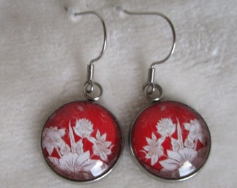 white flower earrings on a red background