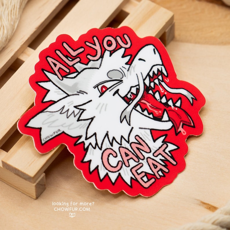 K&ouml;nnte beinhalten: Ein Aufkleber mit einem wei&szlig;en Cartoon-Wolfskopf, roten Augen und einer roten Zunge. Der rosa Text lautet "ALL YOU CAN EAT". Der Aufkleber hat einen roten Rand und befindet sich auf einer Holzoberfl&auml;che.
