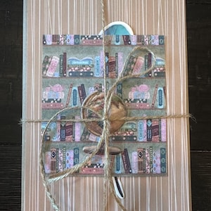 May include: A wrapped package with a brown paper cover and white vertical stripes. A decorative sticker featuring a bookshelf with books labeled "History" and "Fantasy" is affixed to the front. The package is tied with twine.