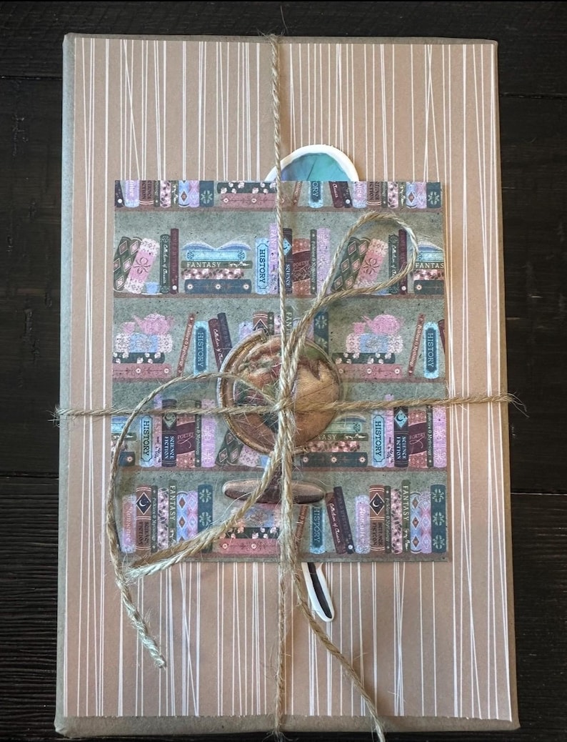 May include: A wrapped package with a brown paper cover and white vertical stripes. A decorative sticker featuring a bookshelf with books labeled "History" and "Fantasy" is affixed to the front. The package is tied with twine.