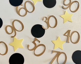 May include: A collection of gold and black confetti featuring numbers from 30 to 90, stars, and circles. The confetti is scattered on a white background.