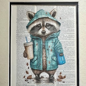 May include: A whimsical illustration of a raccoon wearing a teal hooded jacket, holding a coffee cup, and standing on a dictionary page. The artwork is framed with a black border.