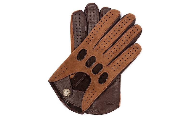Puede incluir: Un par de guantes de conducir de cuero marr&oacute;n con detalles perforados y cierre de bot&oacute;n. Los guantes est&aacute;n hechos de dos tonos de cuero marr&oacute;n, siendo la parte superior de un tono marr&oacute;n m&aacute;s claro.