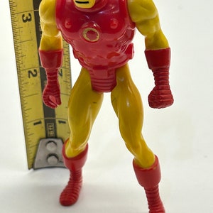 May include: A red and yellow plastic action figure of Iron Man. The figure is approximately 5 inches tall and has a detailed sculpt.