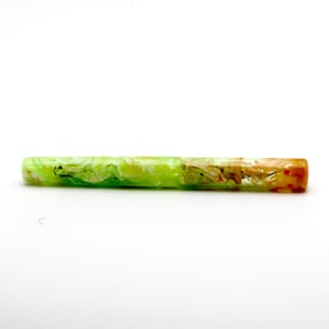 May include: A rectangular pen body with a marbled design. The pen features a gradient of colors, transitioning from green to yellow and ending with brown and orange hues. The pen is made of a translucent material.