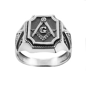 Op de afbeelding: Een zilveren vrijmetselaarsring met een vierkant ontwerp met een passer en een winkelhaak met een 'G' in het midden.