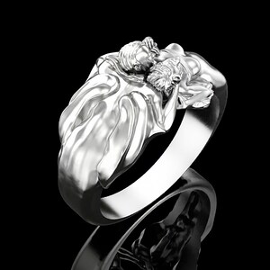 May include: A silver ring featuring a sculpted design of two figures embracing. The figures are intricately detailed and appear to be in a loving embrace.