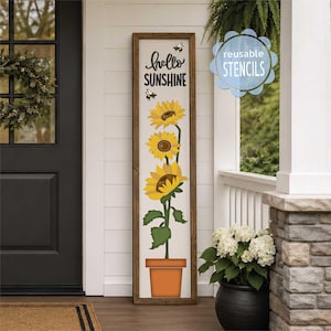 May include: A tall, rectangular wooden sign featuring the text "hello SUNSHINE" in black lettering, accompanied by illustrations of two small bees and a vertical arrangement of three yellow sunflowers growing out of a terracotta-colored pot.