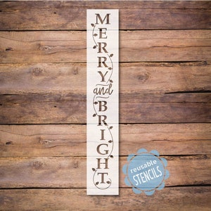 May include: A white wooden stencil with the words "Merry and Bright" in a vertical design. The stencil has a decorative garland design with leaves and lights. The words are in a cursive font. The stencil is on a wooden background. The words "Reusable Stencils" are in a circle on the bottom right corner of the image.