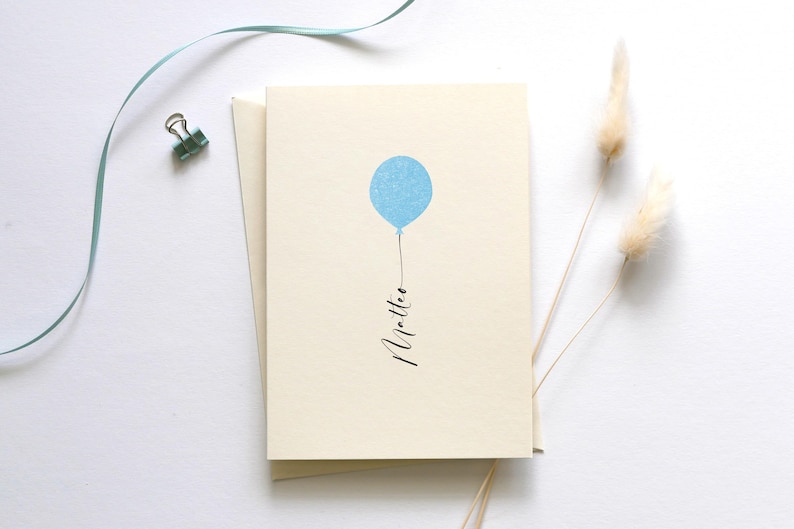 May include: A blank card with a light blue balloon and the word "little" written in black calligraphy.