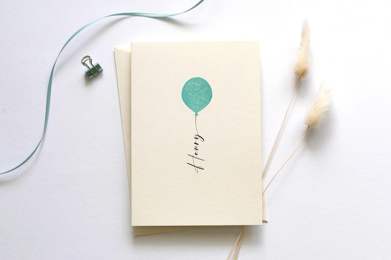 May include: A blank card with a light blue balloon and the name "Henry" written in black cursive.