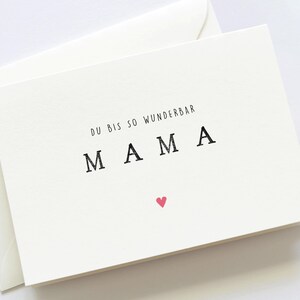 May include: A white card with the text "Du bis so wunderbar MAMA" and a small pink heart.