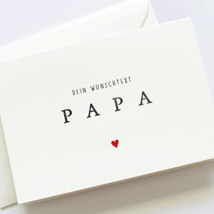 May include: A white card with the text "Dein Wunschtext Papa" and a small red heart.