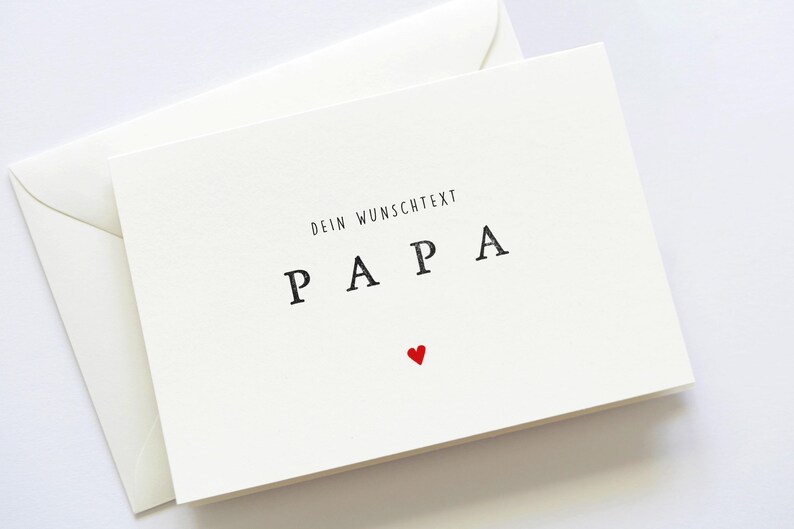 May include: A white card with the text "Dein Wunschtext Papa" and a small red heart.