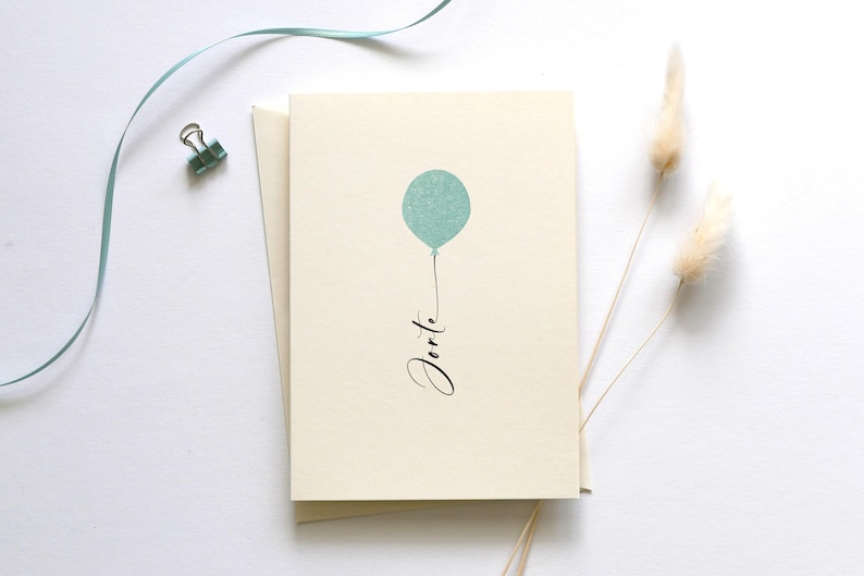 May include: A blank card with a light blue balloon and the word "Forte" written in black calligraphy.