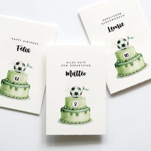 May include: Three birthday cards with watercolor illustrations. Each card features a two-tiered green cake topped with a soccer ball. The cards have names and ages written on them, with text such as "Happy Birthday" and "Alles Gute zum Geburtstag".