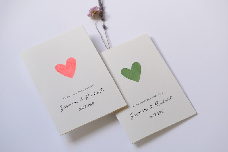 May include: Two wedding cards with a pink and green heart on each. The cards say "Alles Liebe zur Hochzeit" and "Jasmin & Robert" with the date "06-07-2024".