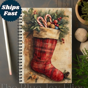 May include: A red and white plaid stocking filled with candy canes, holly, nuts, and ornaments. The stocking is sitting on a vintage background with handwritten text. The Blue Jay Flies is written at the bottom of the image.