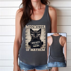 K&ouml;nnte beinhalten: Ein graues Tanktop mit einem schwarzen Katzen-Fahndungsfoto-Design. Die Katze h&auml;lt ein Schild mit der Aufschrift "Bad Kitty #15518465 Police Dept.". Der Text auf dem Shirt lautet "Meowster of Mayhem".