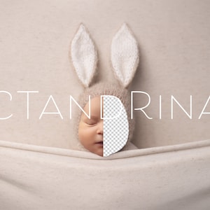 May include: A newborn baby wearing a beige knitted bunny hat with long ears. The baby is sleeping and the hat is covering the baby's face. The baby is lying on a white blanket. The text "CTANDRINA" is written in white letters on a beige background.