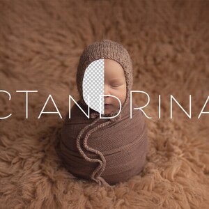 May include: A newborn baby wrapped in a brown swaddle, wearing a brown knitted hat. The baby's face is partially obscured by the hat. The background is a brown fuzzy surface. The text "CTANDRINA" is visible in the image.