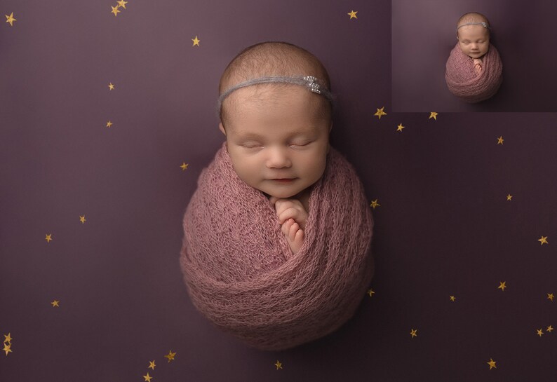 May include: A newborn baby girl is sleeping peacefully, wrapped in a soft pink swaddle. She is wearing a headband with a small, sparkly embellishment. The background is a deep purple with gold stars.